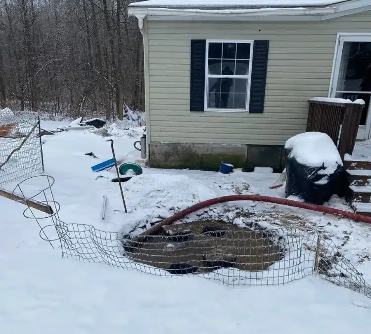 PumperJack Septic performing residential septic tank pumping in snowy winter conditions at a rural Finger Lakes home