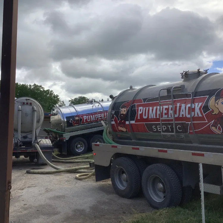 PumperJack septic trucks for municipal sludge hauling and wastewater services, featuring branded tanks and hoses in an outdoor setting.