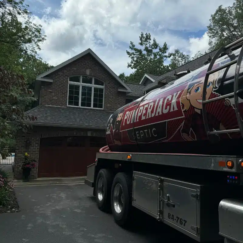 Residential Sewer Clean-Out PumperJack Septic truck parked in residential driveway in front of brick home for routine sewer clean-out service