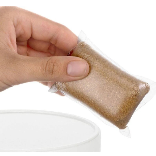 Hand holding a biodegradable septic tank additive pod, used to maintain healthy bacteria levels in home septic systems